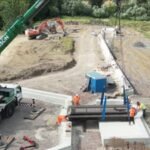 An English town installed a six-metre swing bridge whose deck contains the equivalent of 140 recycled plastic bottles per square metre and can be manually opened for passing boats