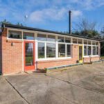 ​A New Zealand couple bought an abandoned school, then spent three years and about NZ$250,000 turning the classroom into a home and chalet; the property is now listed for enquiries over NZ$595,000